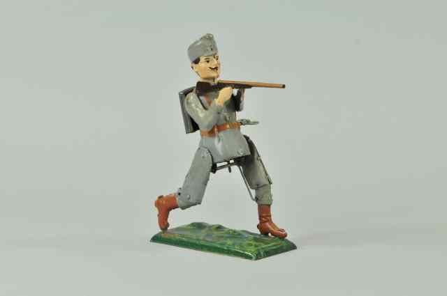 Appraisal: SOLDIER SHOOTING RIFLE Germany hand painted tin interesting clockwork action