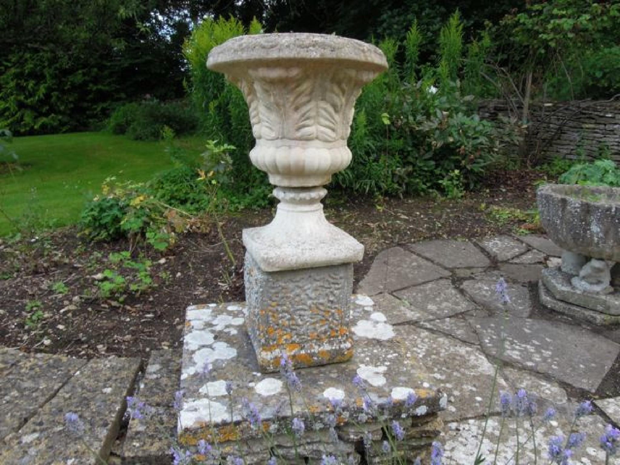 Appraisal: A pair of reconstituted acanthus leaf shaped urns on square