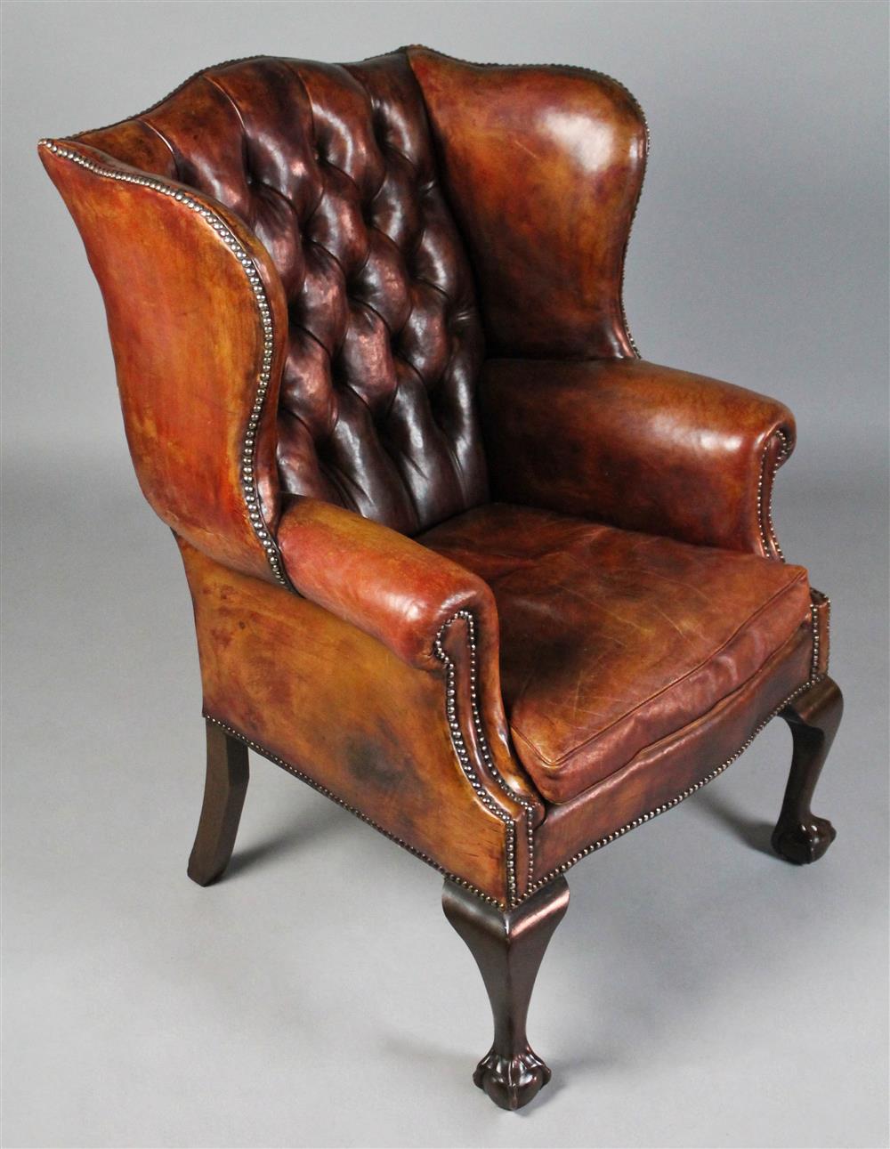 Appraisal: GEORGE II STYLE BURNISHED BROWN TUFTED LEATHER WING CHAIR WITH