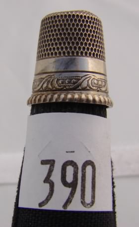 Appraisal: Silver tone thimble with ornate design above rope edged band