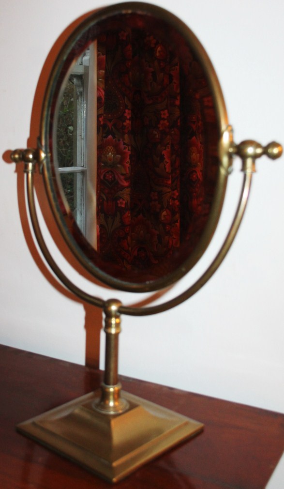 Appraisal: A brass framed oval table mirror with bevel plate