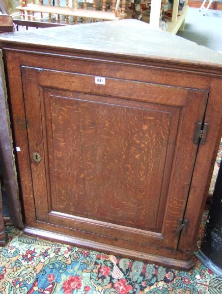 Appraisal: A George III oak hanging corner cupboard the single panelled