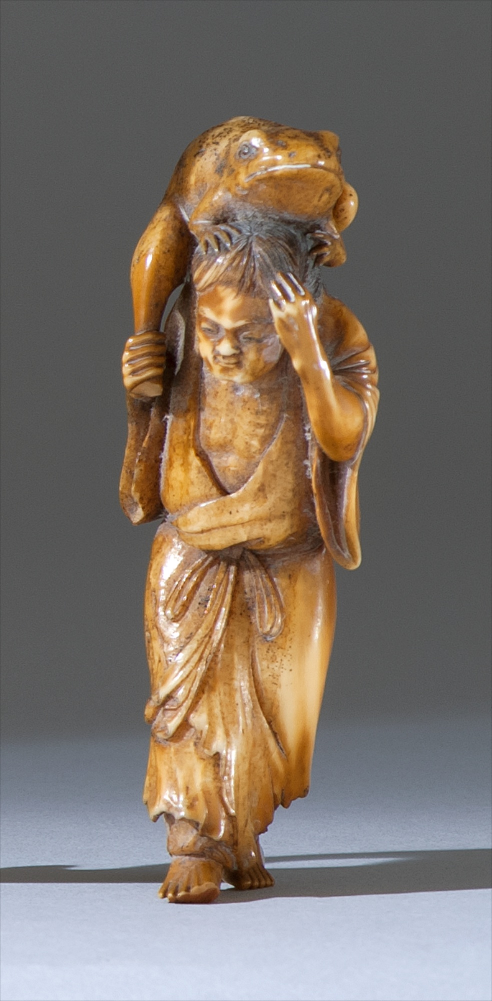 Appraisal: CARVED WALRUS IVORY OKIMONO th CenturyDepicting Gama Sennin with a