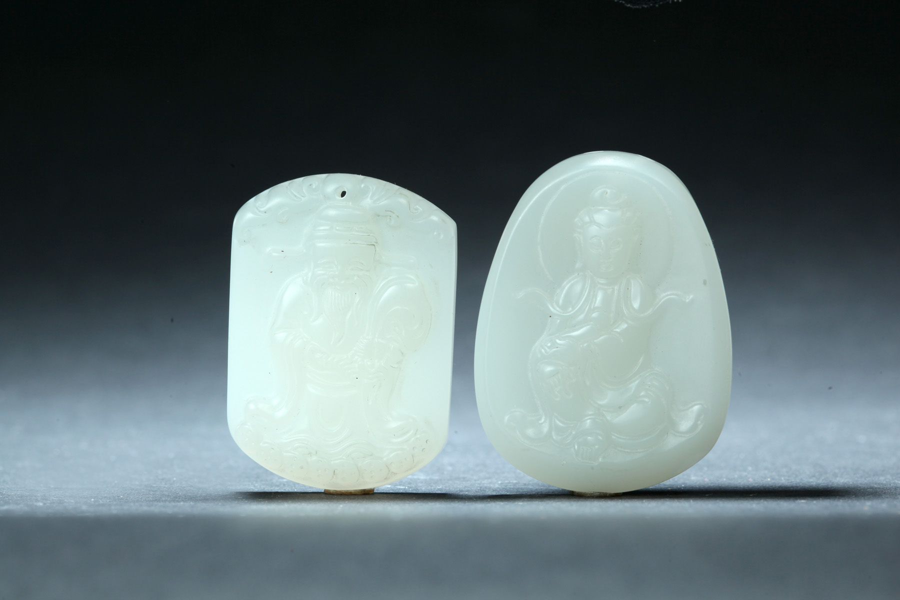 Appraisal: TWO JADE PENDANTS China th century Quanyin Buddha and money