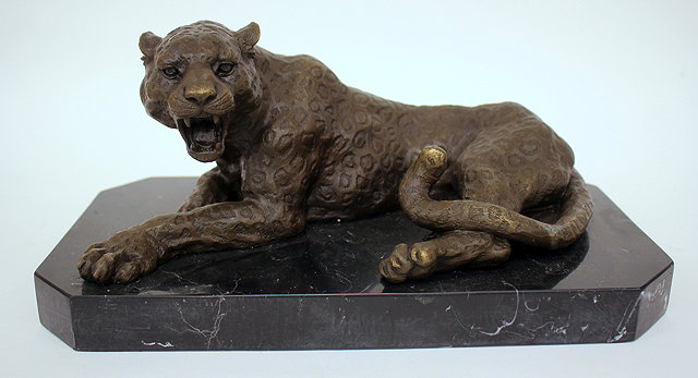 Appraisal: A CONTEMPORARY BRONZE SCULPTURE of a recumbent leopard on a