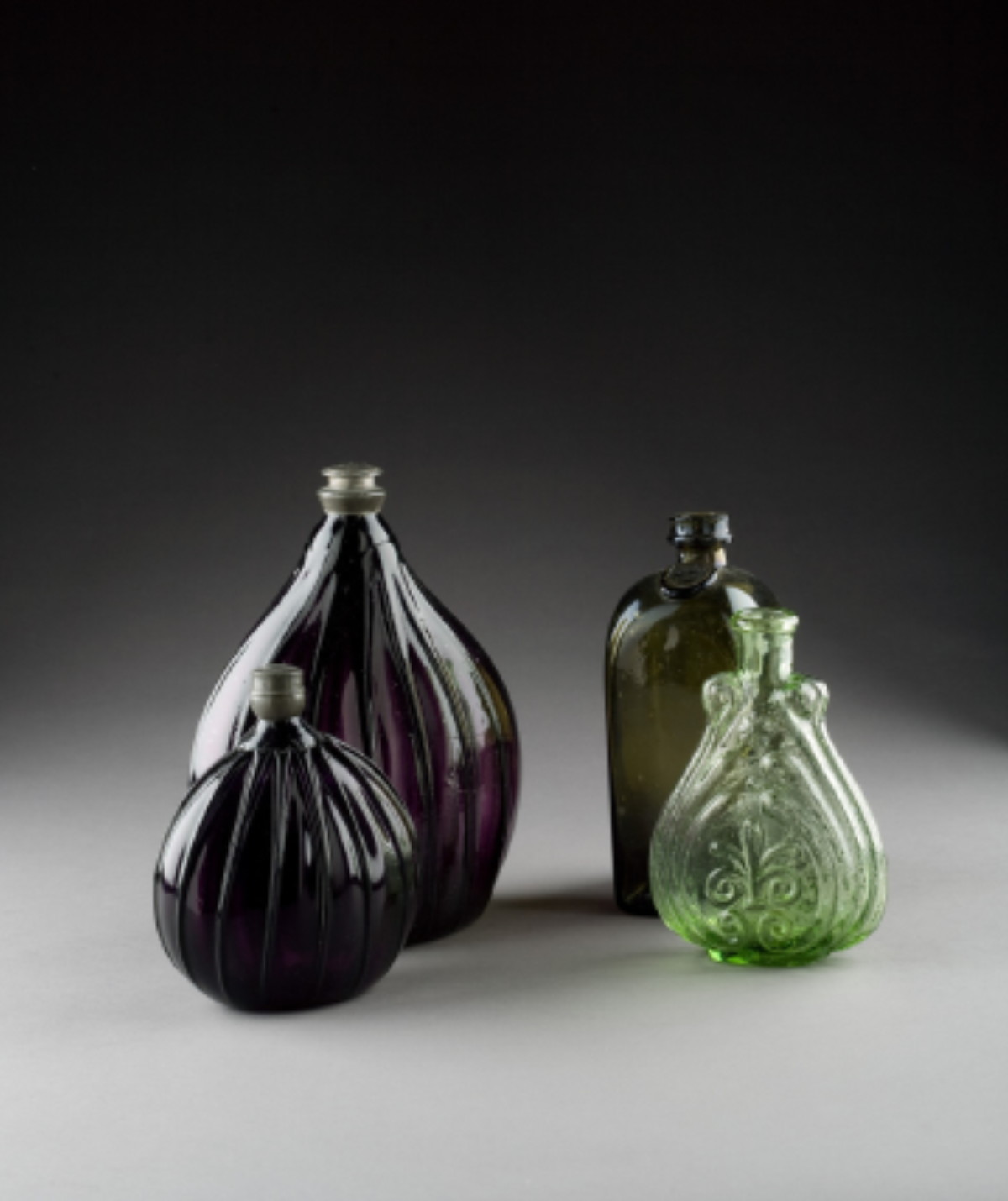 Appraisal: TWO PATTERN-MOLDED DEEP PURPLE GLASS PITKIN-TYPE BOTTLES NINETEENTH CENTURY Each