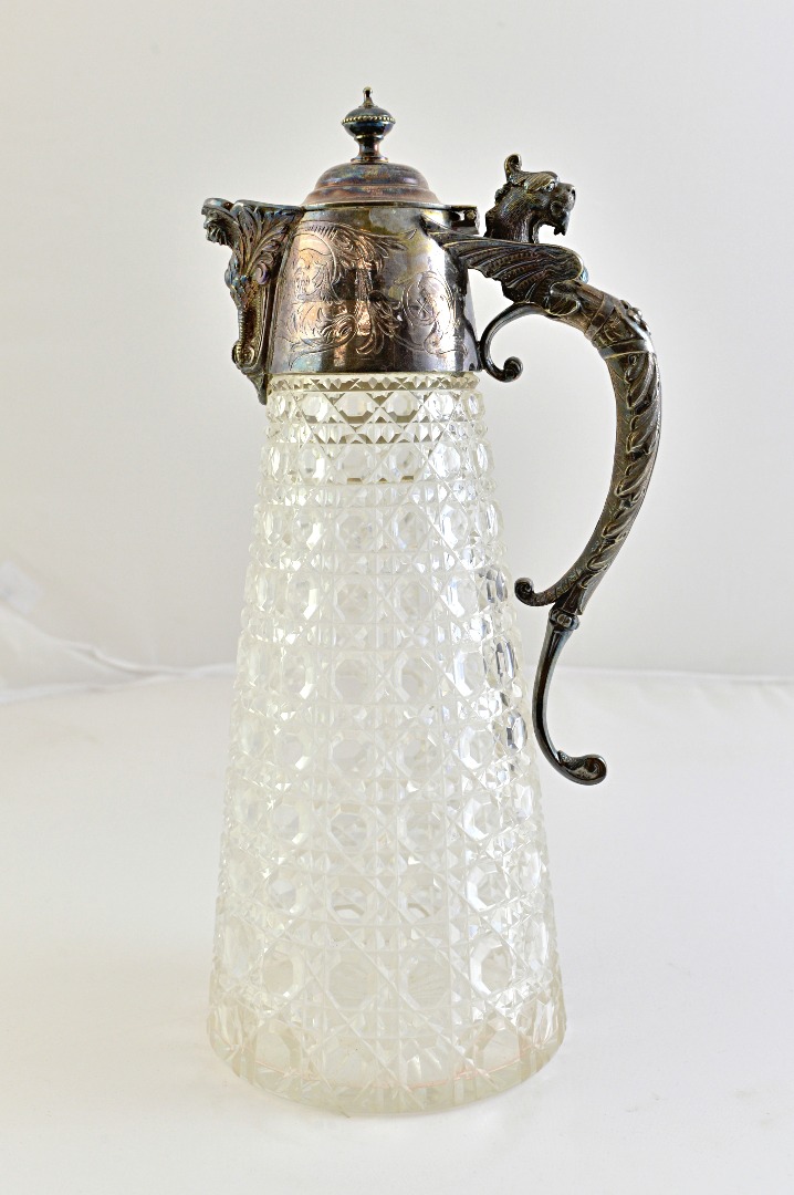 Appraisal: A silver plated metal mounted faceted glass claret jug the