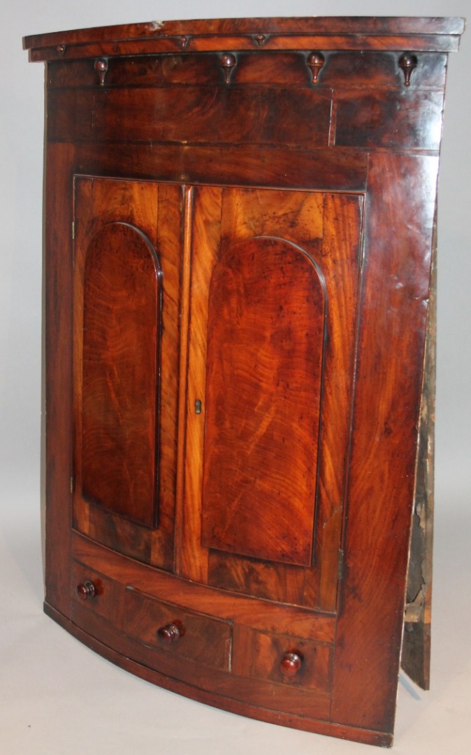 Appraisal: An thC stained walnut and mahogany hanging corner cupboard the