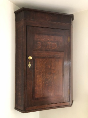 Appraisal: A George III oak hanging corner cupboard with moulded top