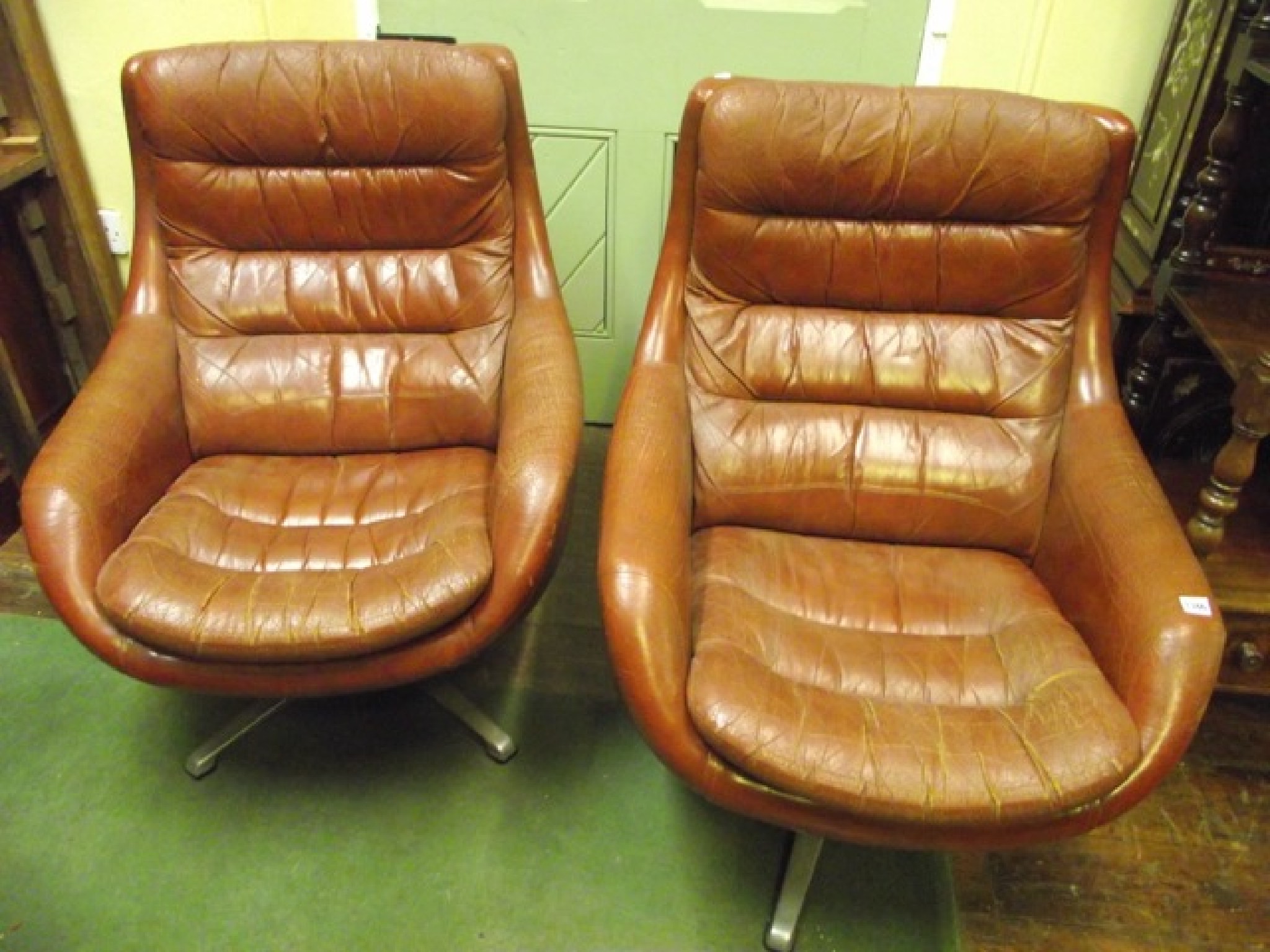 Appraisal: A pair of s swivel chairs with mid brown upholstered