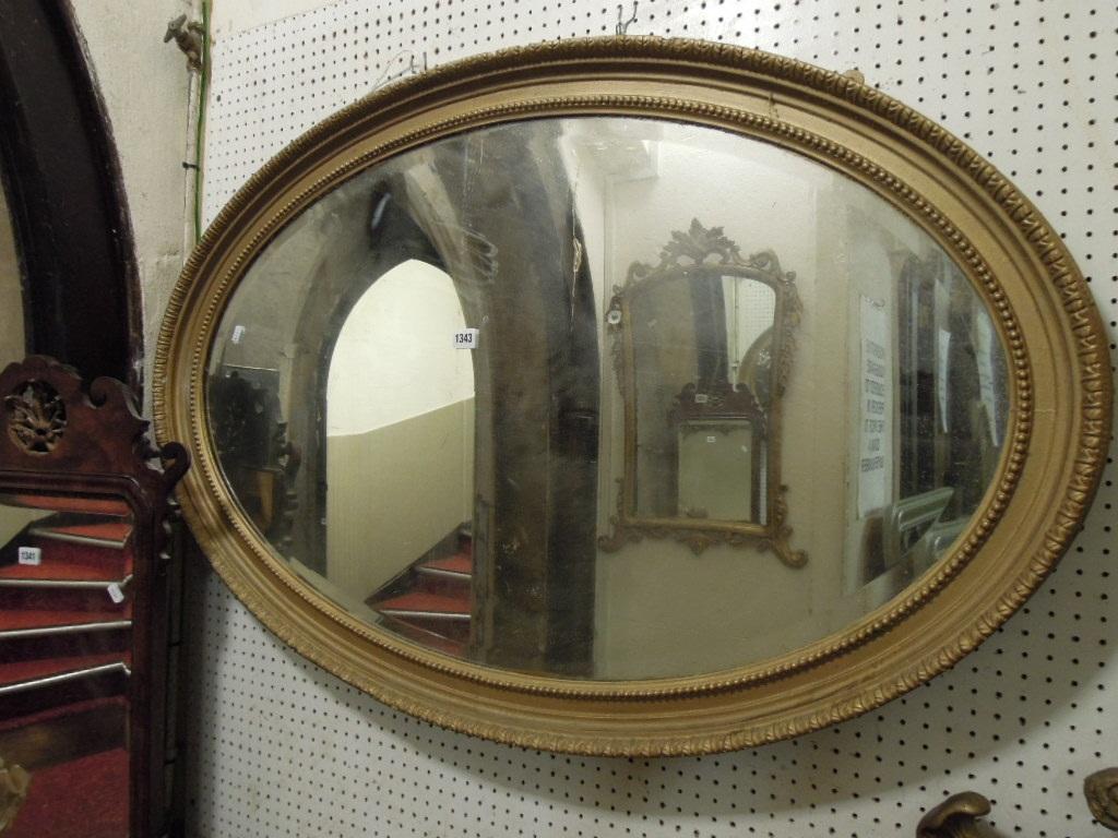 Appraisal: A gilt framed wall mirror of oval form with bevelled