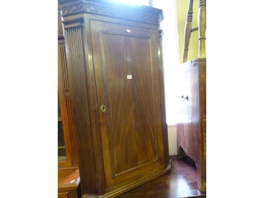 Appraisal: A Georgian mahogany hanging corner cupboard with moulded cornice dentil