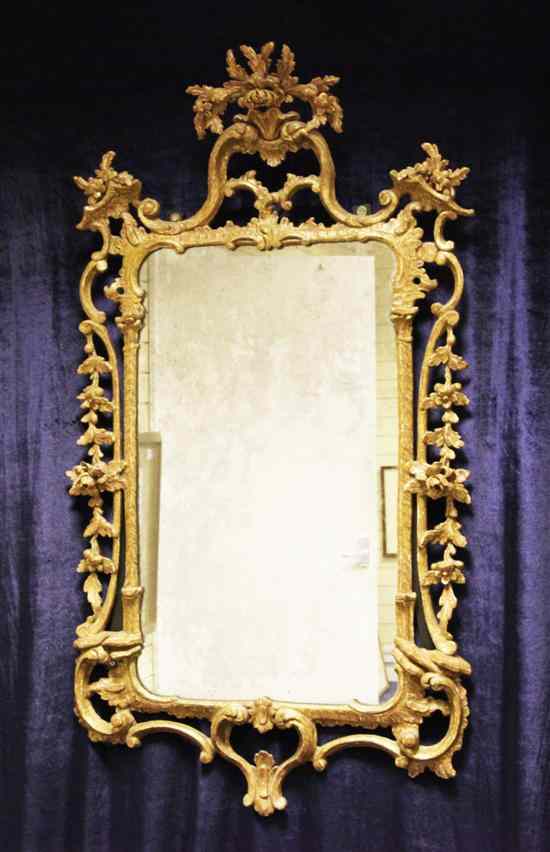 Appraisal: An th century carved and painted giltwood and gesso mirror