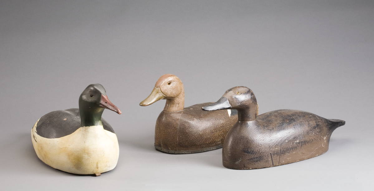 Appraisal: THREE CARVED AND PAINTED DECOYS Including a cloth-over-cork Herter's Black