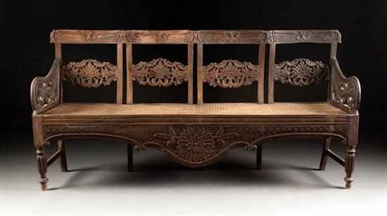 Appraisal: Indonesian carved wood cane-seat chair-back settee with carved palm and