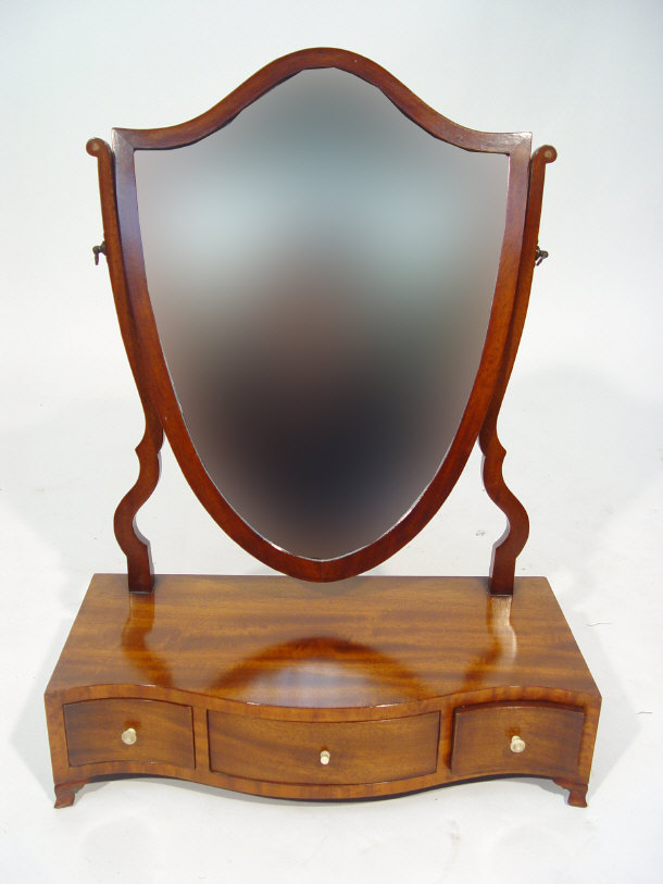 Appraisal: Mahogany shield shaped toilet mirror on a serpentine fronted base