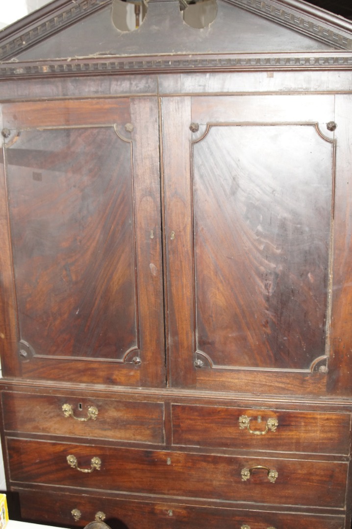 Appraisal: A George III mahogany linen press with a broken arched