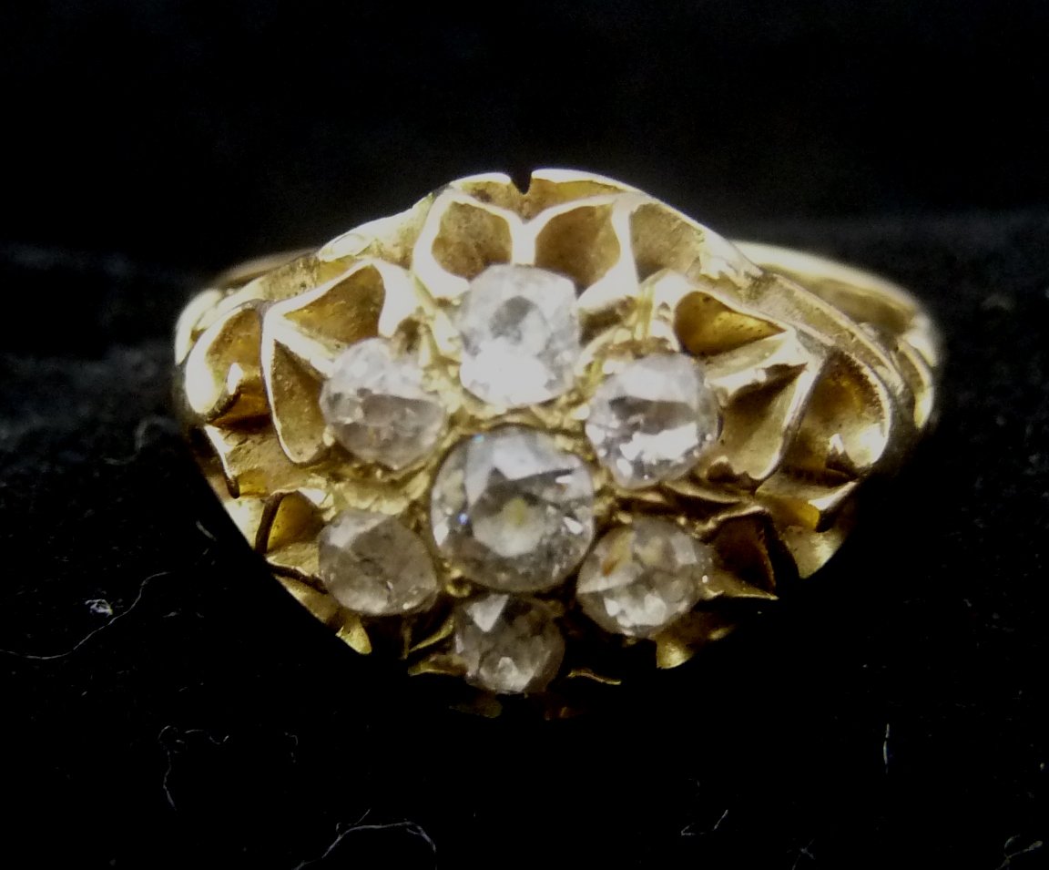 Appraisal: A diamond cluster ring claw set in a pierced setting