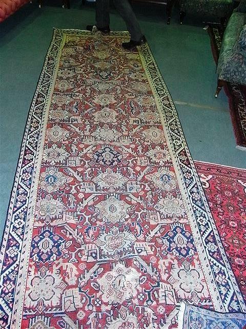 Appraisal: A HAMADAN RED GROUND RUNNER with traditional geometric designs within