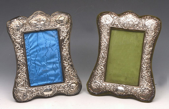 Appraisal: A PAIR OF SILVER PHOTO FRAMES with embossed cherub and