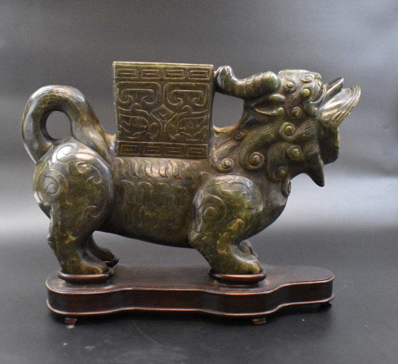 Appraisal: A Chinese spinach jade Foo Lion vase with wood base