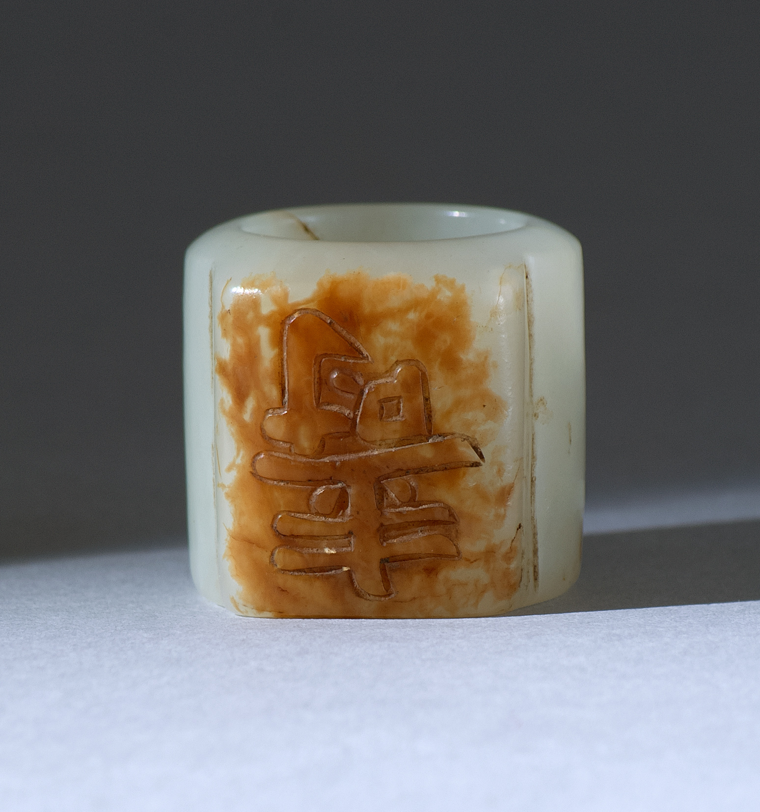 Appraisal: WHITE AND RUSSET JADE SCHOLAR'S RING th CenturyWith relief-carved shou