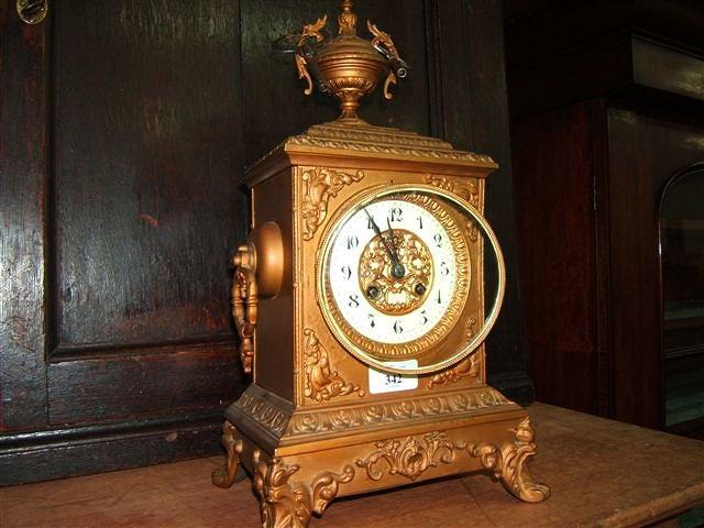 Appraisal: A mantel clock with scrolling decoration the dial with Arabic