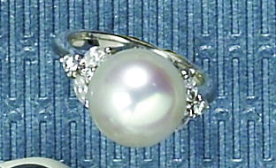 Appraisal: DIAMOND AND PEARL RING Platinum lady's ring centering one mm