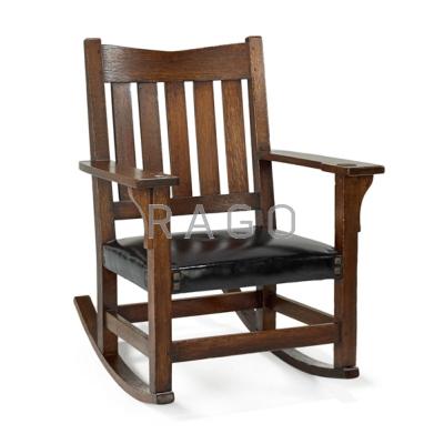 Appraisal: GUSTAV STICKLEY Rocking chair Oak leather and brass tacks Red