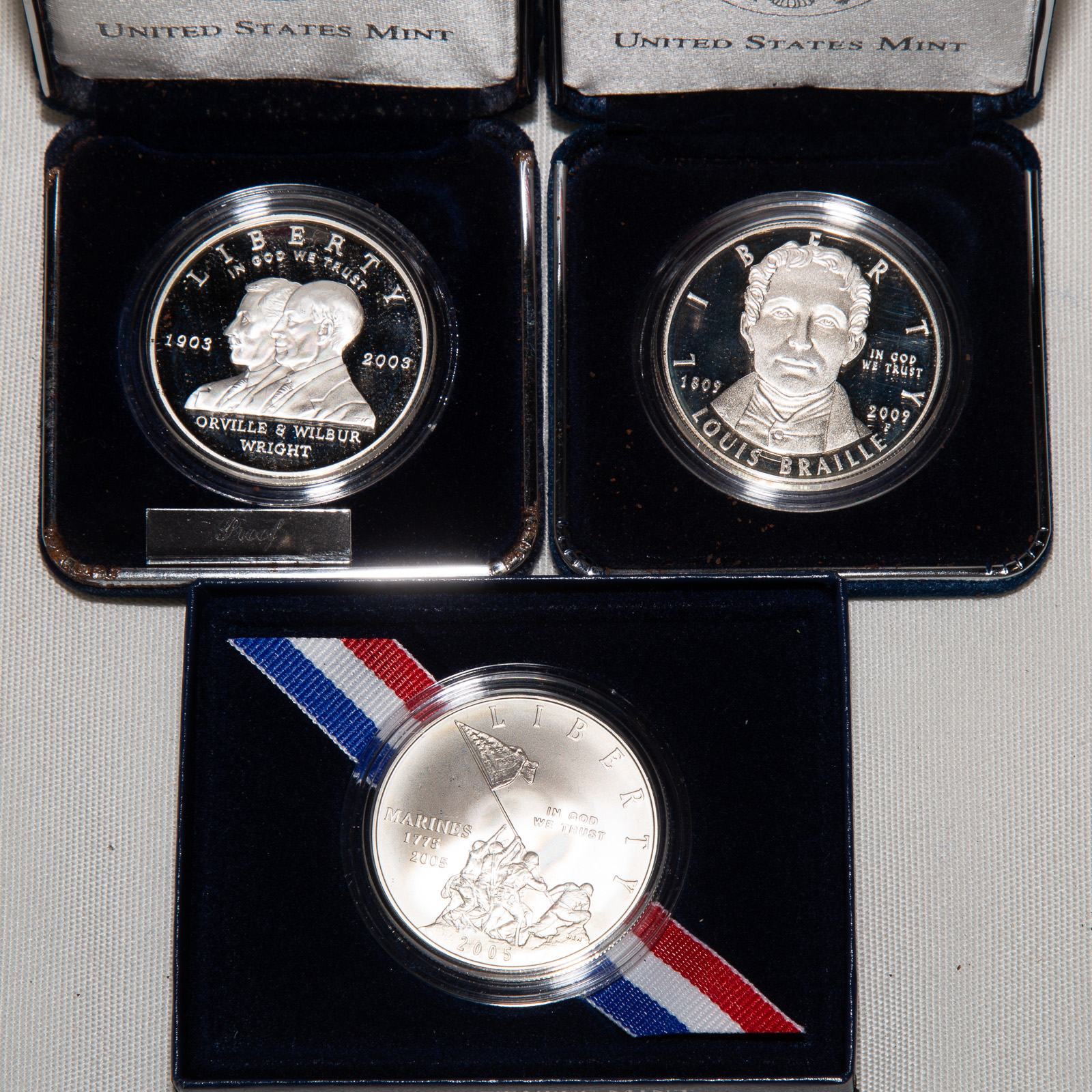 Appraisal: THREE COMMEMORATIVE SILVER DOLLARS Louis Braille Proof Marine Corps Unc