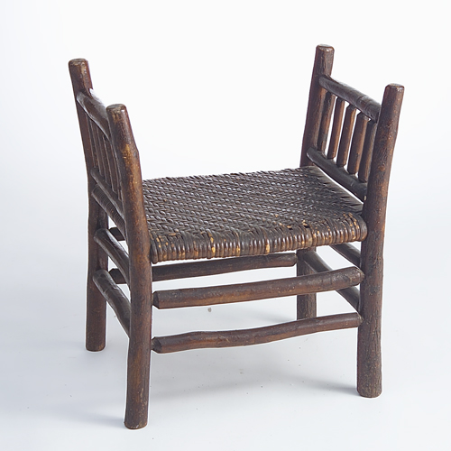 Appraisal: Rustic window bench with spindled sides and woven reed seat