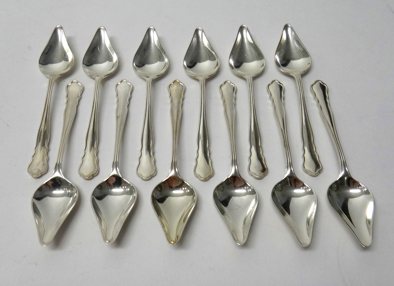 Appraisal: A set of twelve silver grapefruit spoons having shaped handles