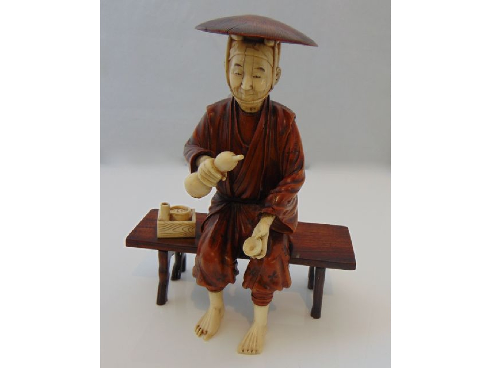 Appraisal: An antique figure of a seated Oriental male principally in