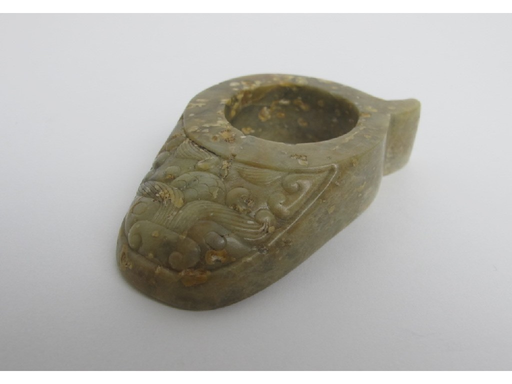 Appraisal: A Chinese archaic jade archer's ring with mask carved disc