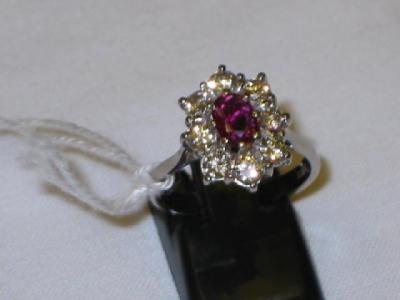 Appraisal: A RUBY AND DIAMOND CLUSTER RING with single ruby surrounded