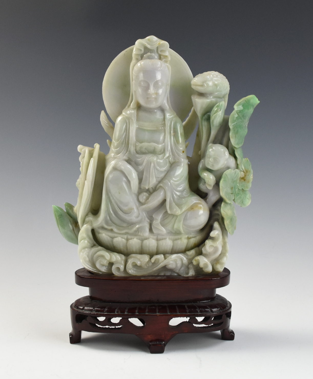 Appraisal: CHINESE JADEITE GUANYIN WITH WOOD STAND The translucent jadeite of