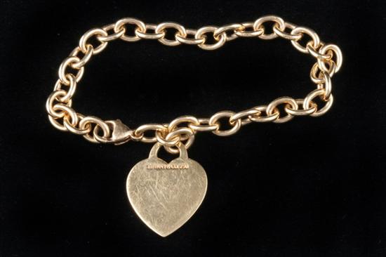 Appraisal: TIFFANY CO K YELLOW GOLD OVAL-LINK BRACELET SUSPENDING BRIGHT-POLISHED HEART