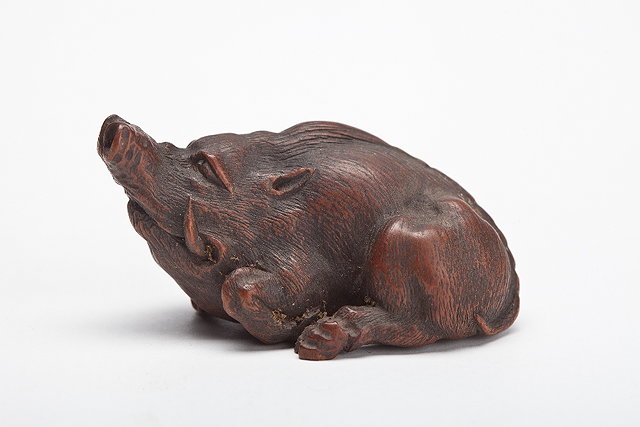 Appraisal: A JAPANESE WOOD NETSUKE of a reclining boar signed Masatomo