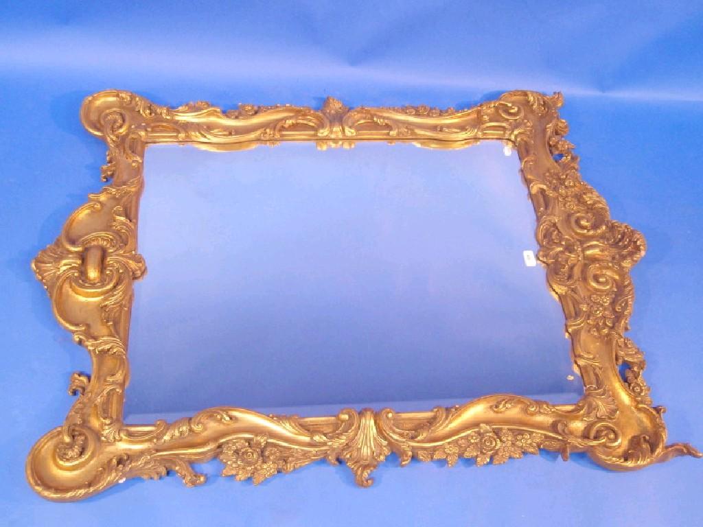 Appraisal: An ornate gilt framed bevel edge wall mirror decorated with