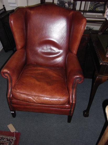 Appraisal: A GEORGIAN STYLE LEATHER WING BACK ARMCHAIR with brass studded