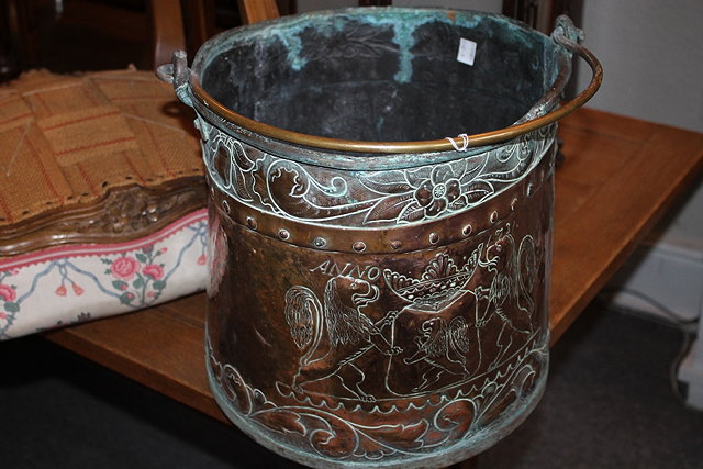 Appraisal: A COPPER EMBOSSED COAL BUCKET with brass swing handle embossed