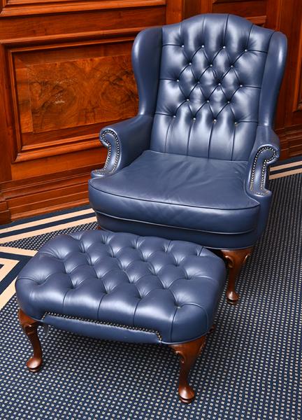 Appraisal: LEATHER UPHOLSTERED BUTTON BACK WING ARMED CHAIR WITH FOOTSTOOL