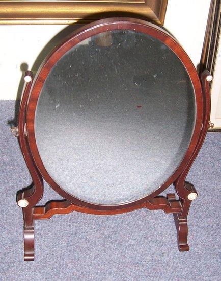 Appraisal: A Victorian oval swing frame toilet mirror on splay feet