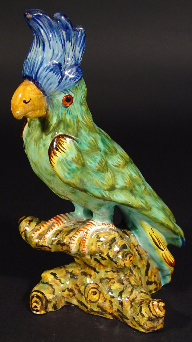 Appraisal: Faience glazed pottery parrot seated on a branch with glass