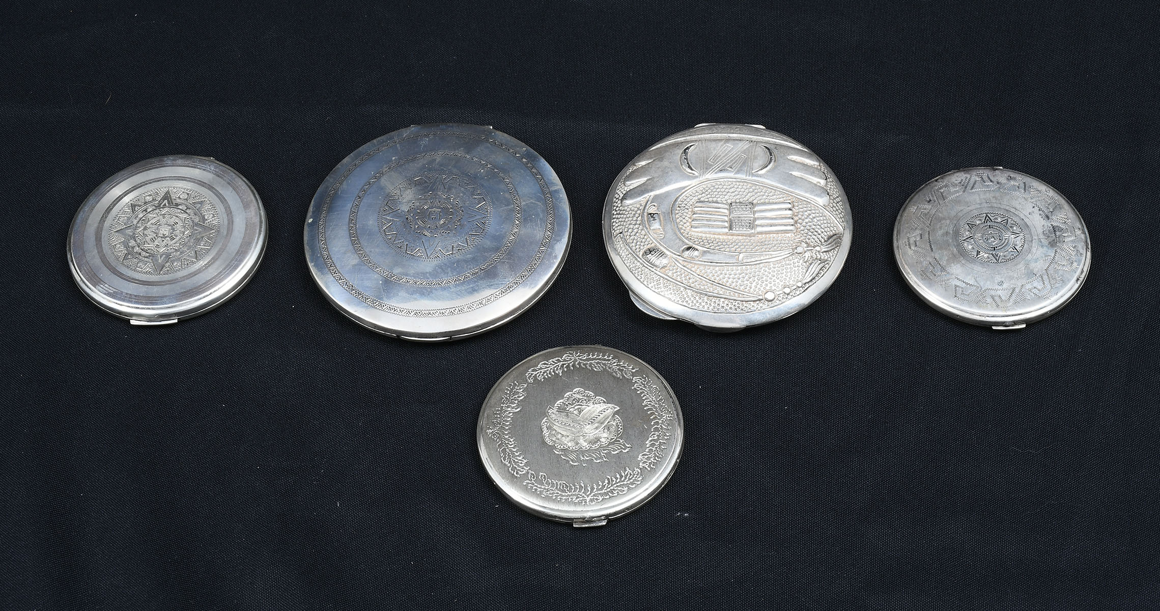 Appraisal: STERLING MEXICAN COMPACTS Sterling Silver compacts having etched raised Mexican