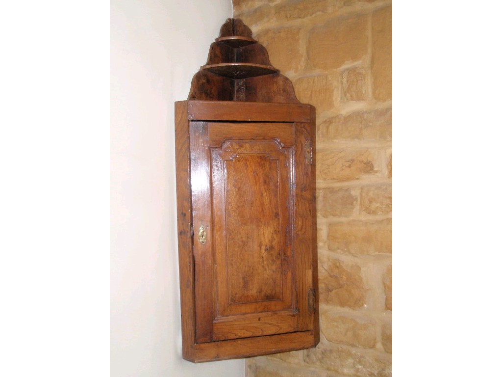 Appraisal: An thC elm hanging corner cupboard with tapering shelves cm