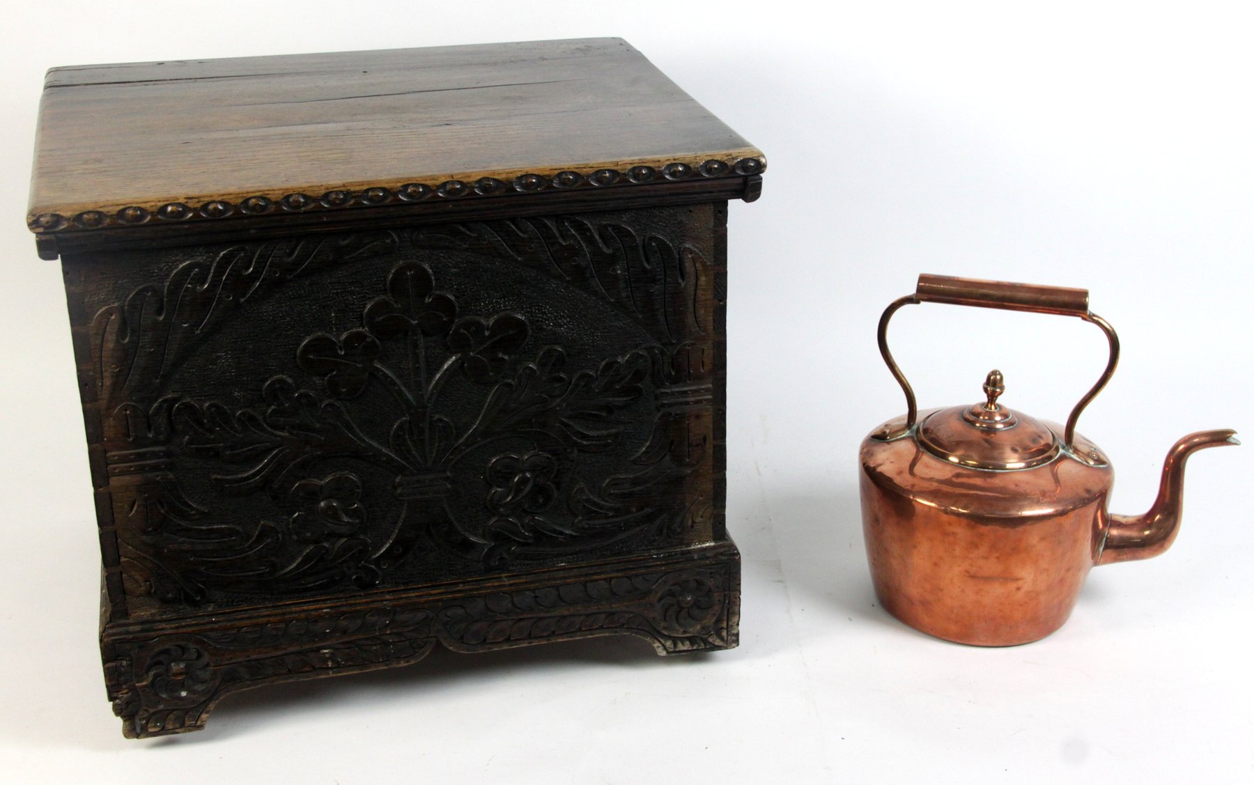 Appraisal: An oak box with hinged lid and carved panel front