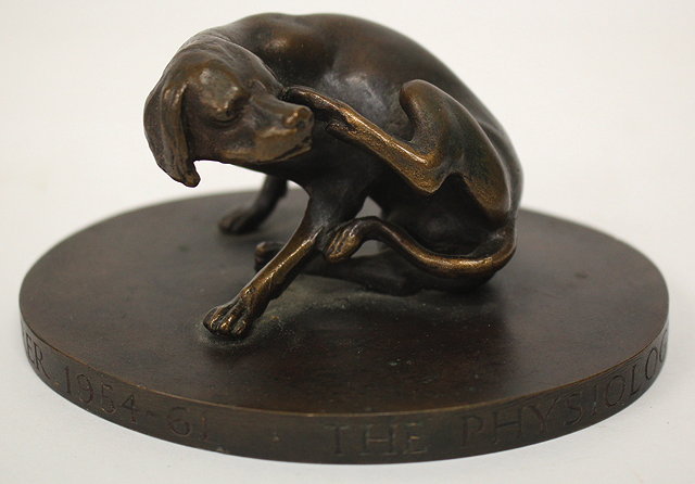 Appraisal: A SMALL BRONZE SCULPTURE OF A DOG enjoying a scratch