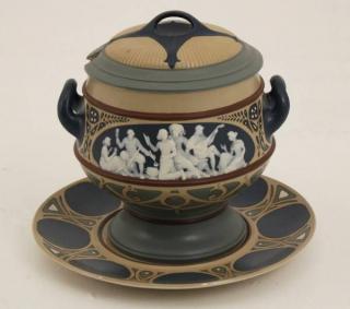 Appraisal: METTLACH PORCELAIN COVERED TUREEN WITH UNDERPLATTER HAVING RAISED FIGURES IN