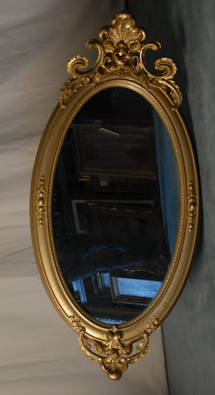 Appraisal: An Oval Gilt Rococo Wall Mirror having a tall carved